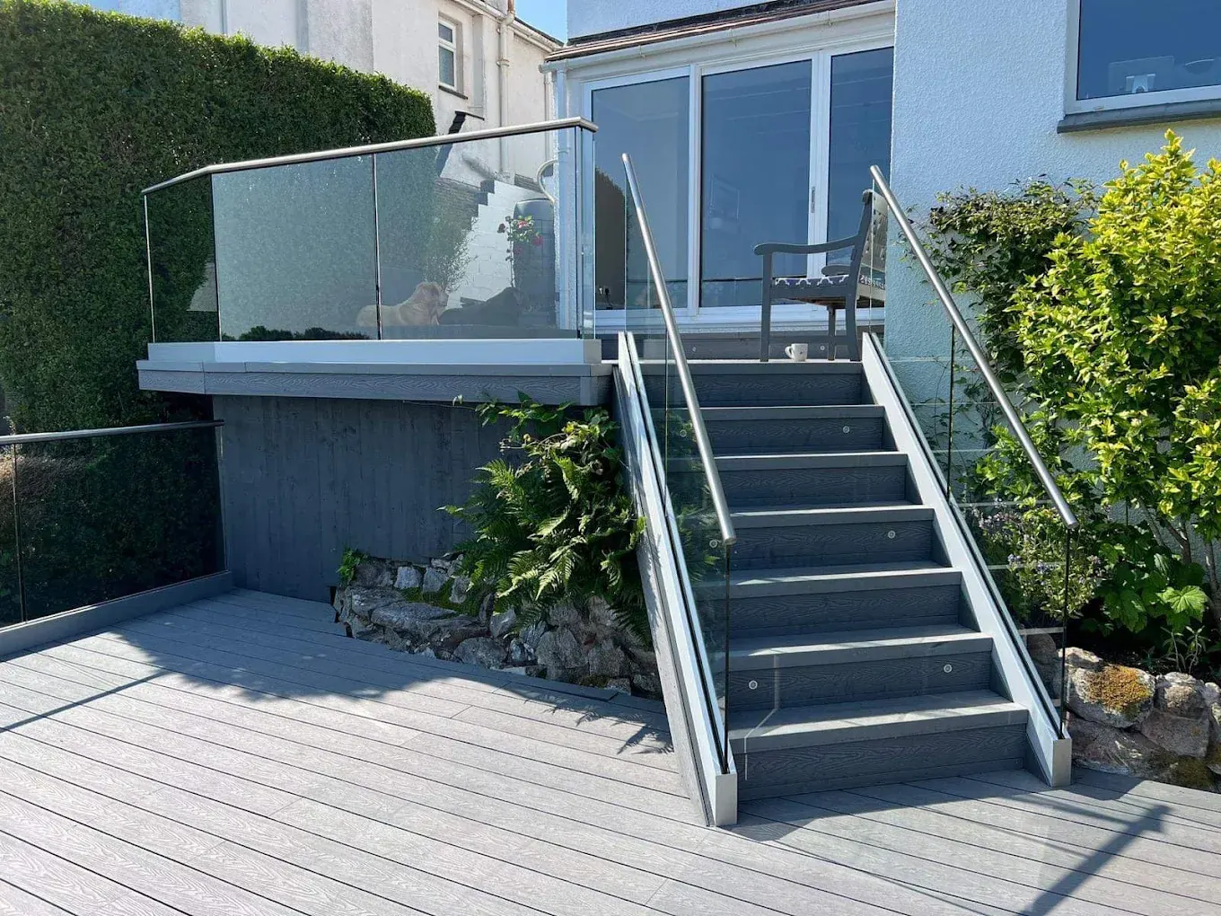Split level grey composite deck with a glass balustrade