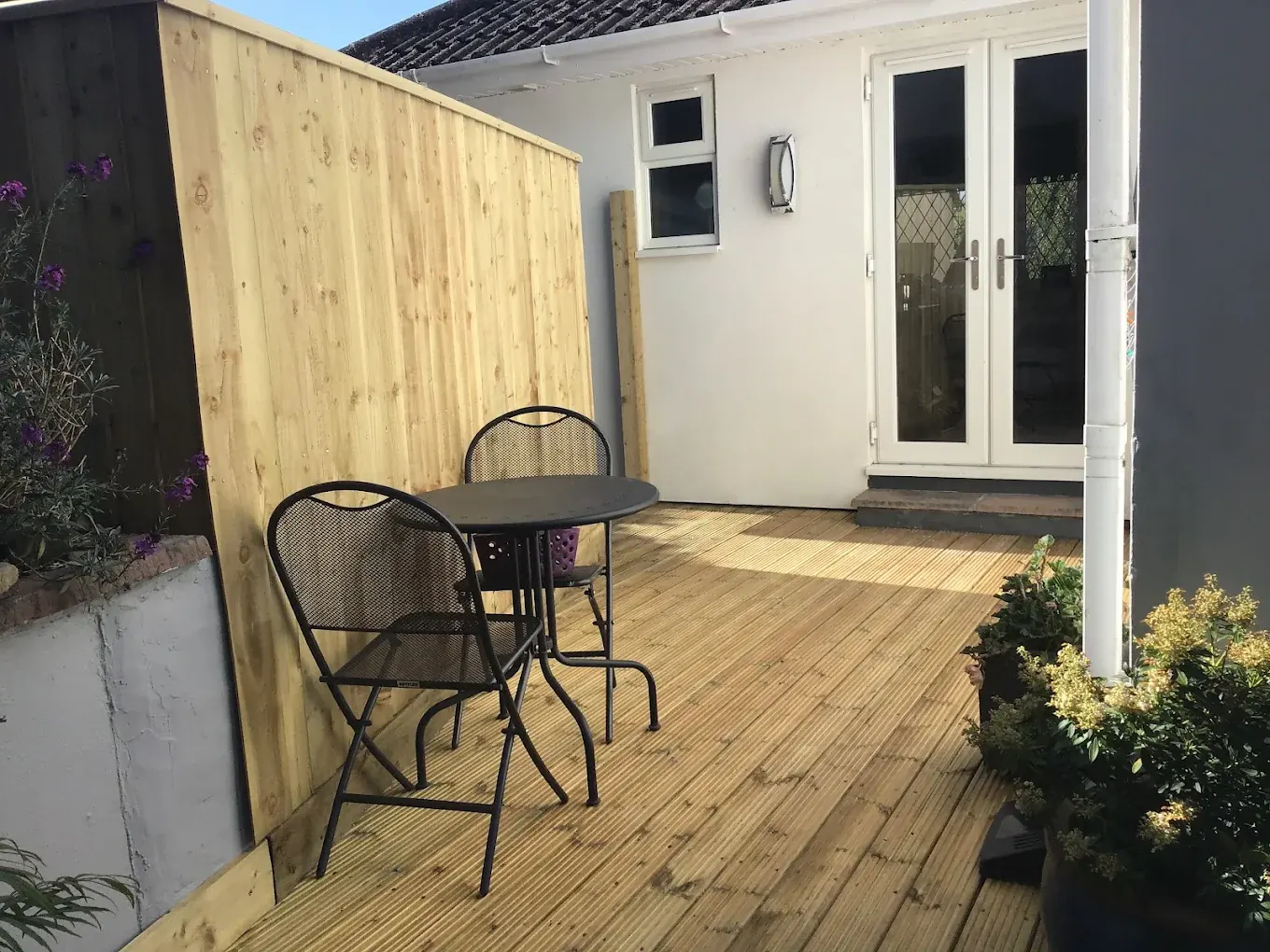 Courtyard timber decking backed by a close board privacy screen