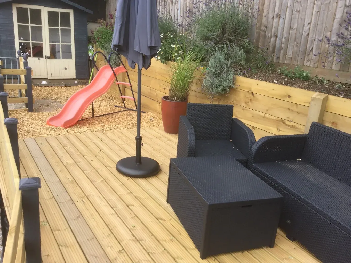 Family garden timber deck built above a sleeper retaining wall