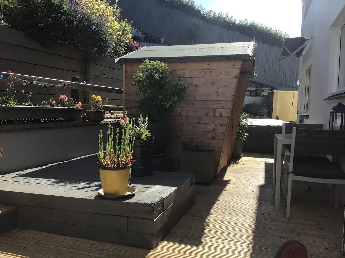 Timber decking terrace edged with sleeper raised beds